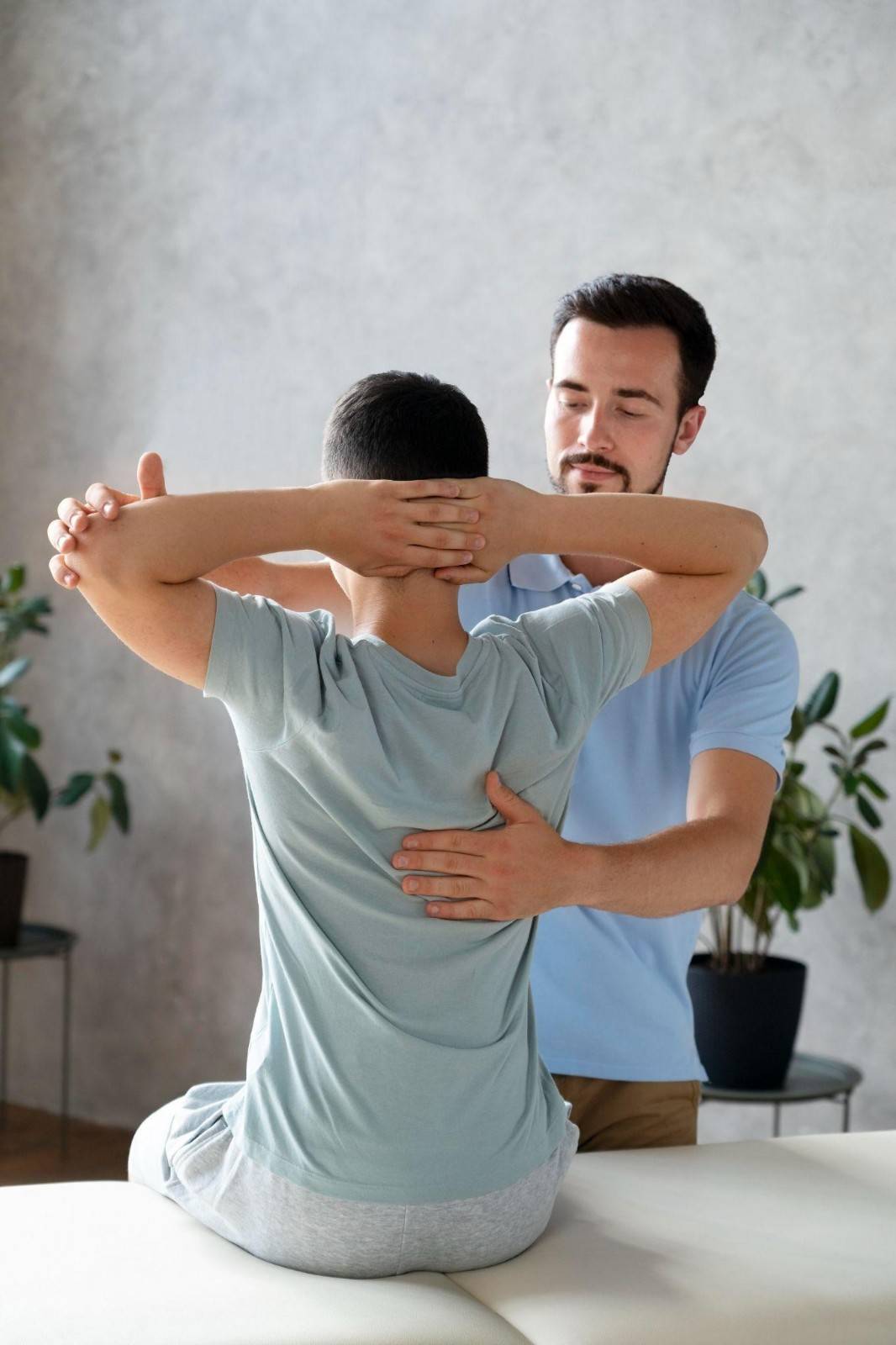 Physical therapist guiding a patient through an upper body rehabilitation exercise during a therapy session.