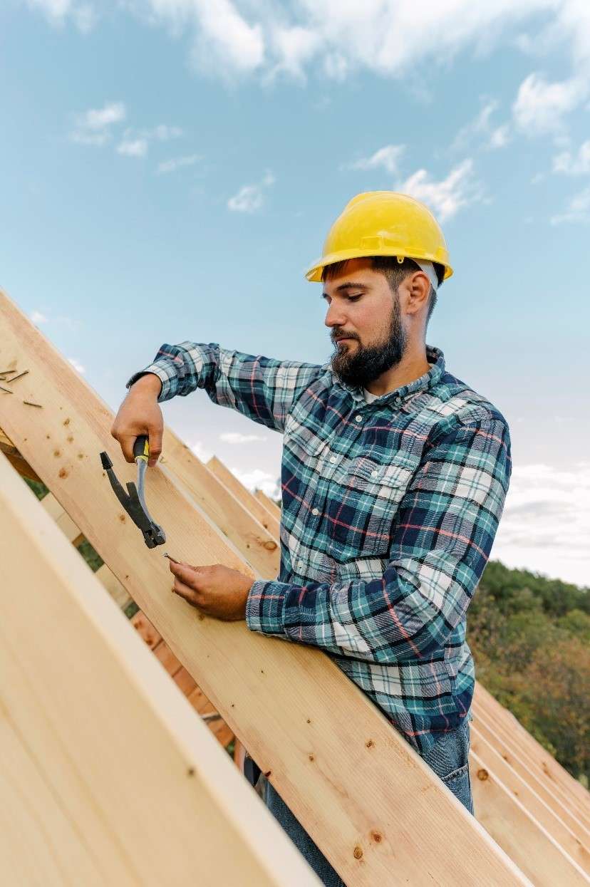 Professional roofing contractor installing a new residential roof during a roof construction project.