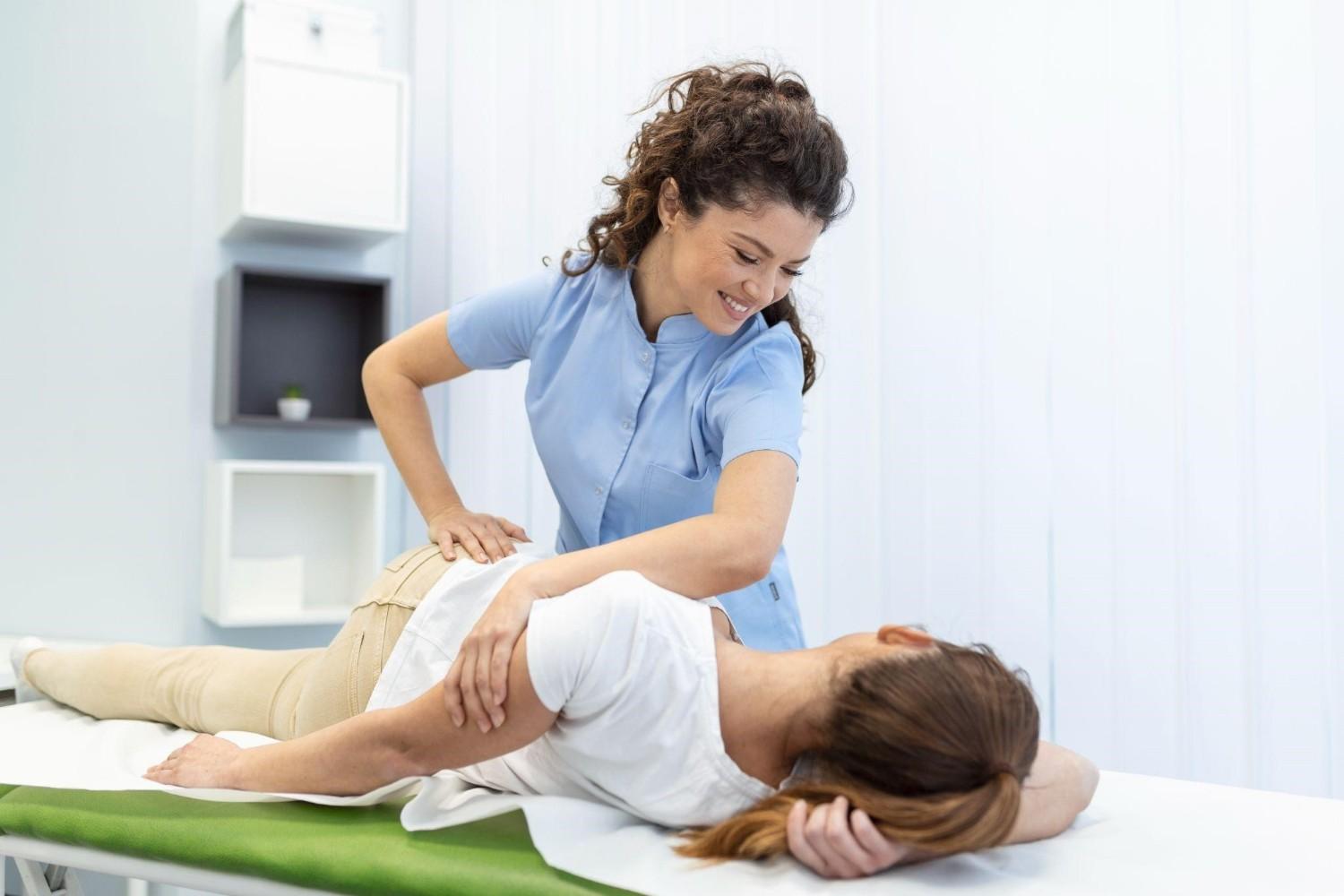 Physical therapist performing manual therapy to relieve back pain and improve patient mobility.