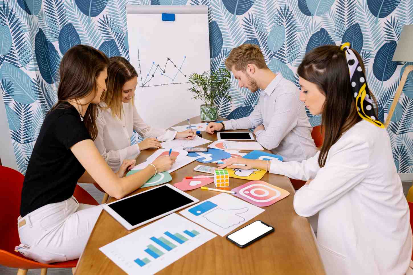 Digital marketing team collaborating on a social media strategy using printed platform icons.