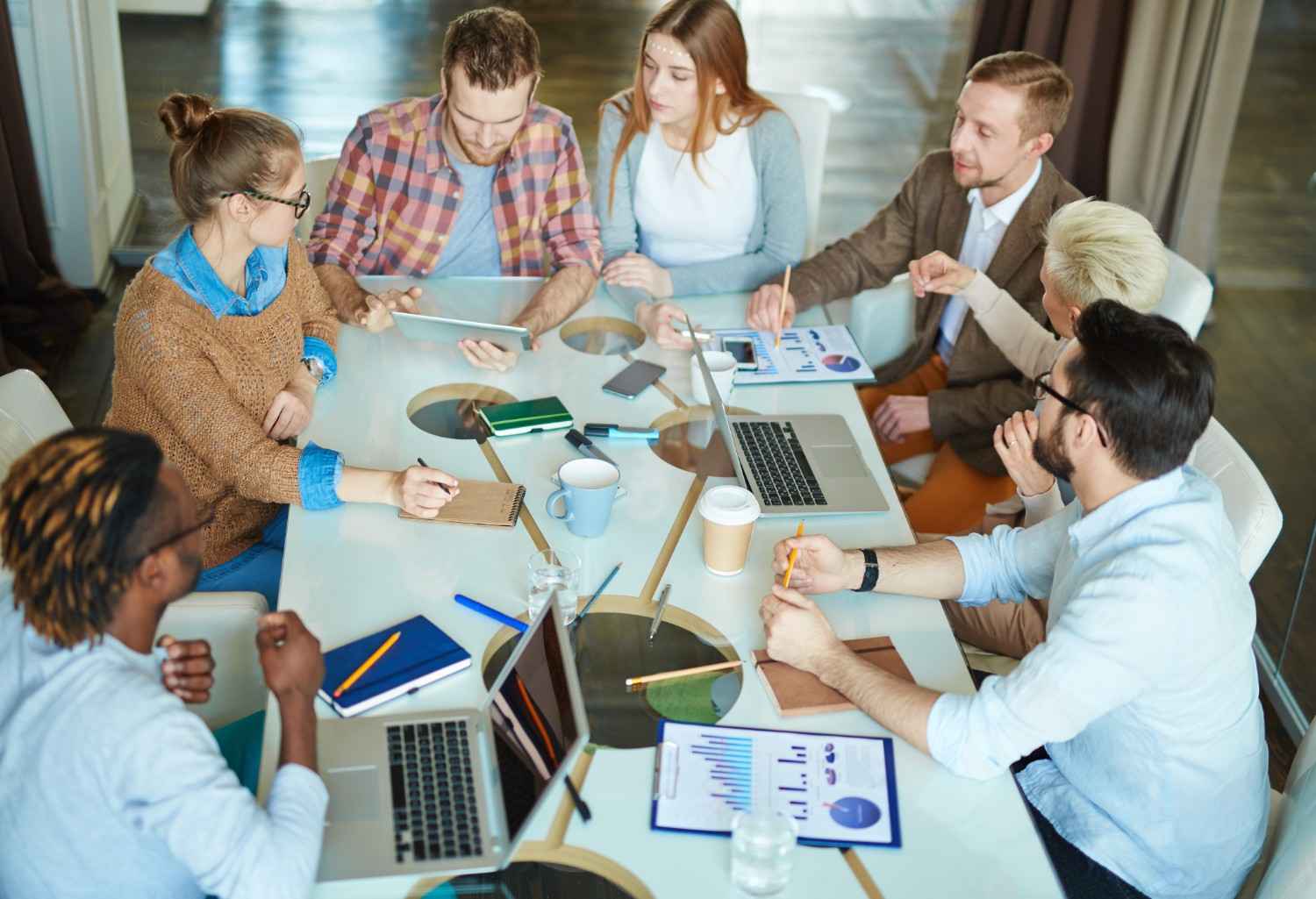 Diverse digital marketing team analyzing performance charts and data during a strategy meeting.