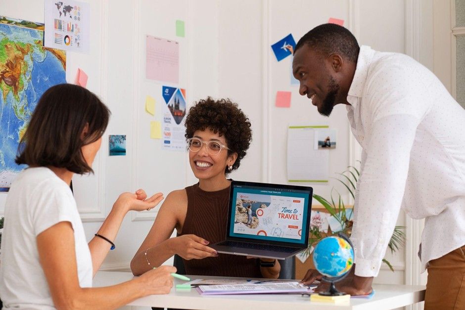 Marketing team reviewing a custom travel website design on a laptop.