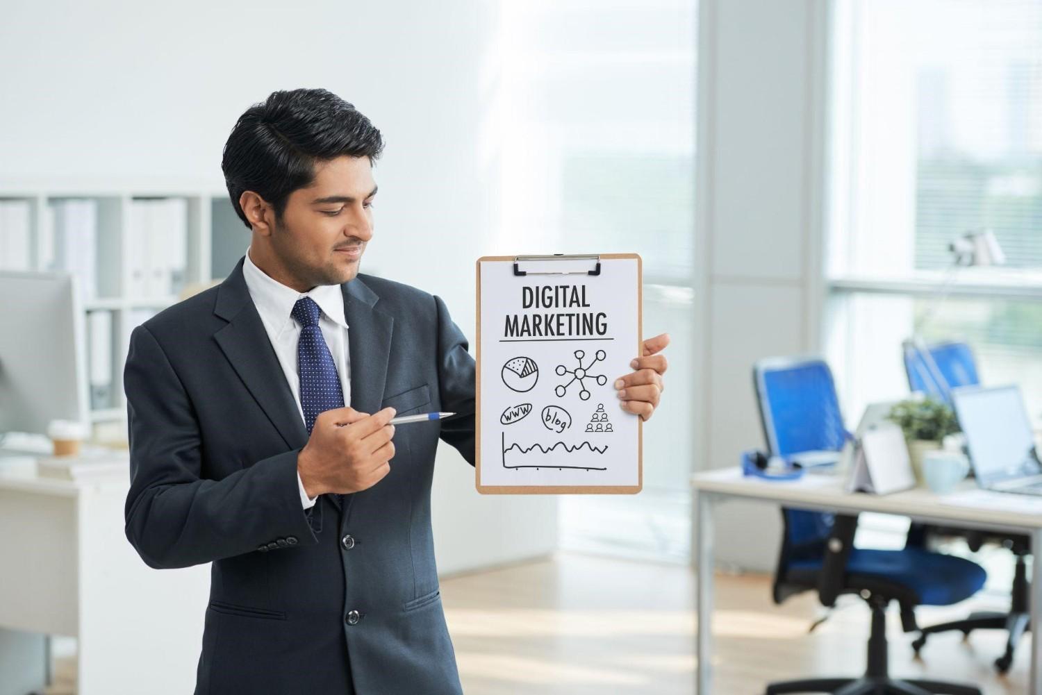 Professional man in a suit pointing to a digital marketing strategy diagram on a clipboard.